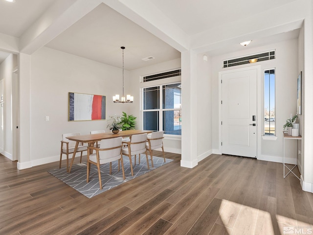 entrance foyer with dark wood-style floors, a chandelier, beam ceiling, and baseboards