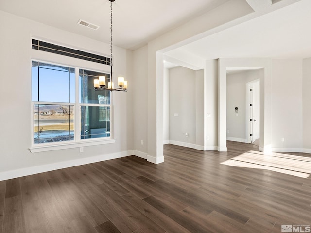 unfurnished dining area with baseboards, dark wood-style flooring, visible vents, and an inviting chandelier