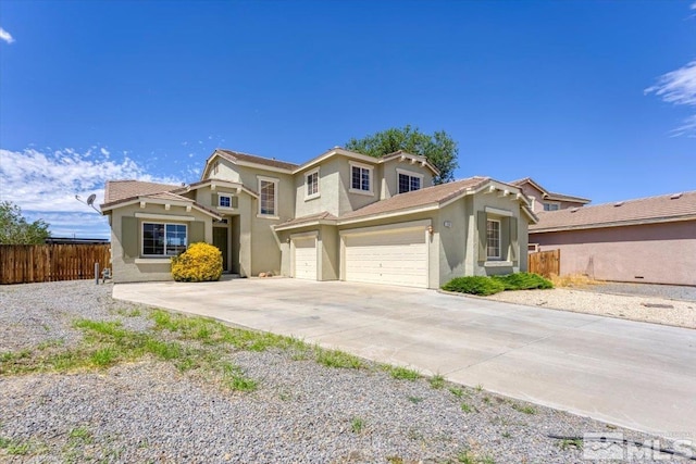 view of front of property featuring driveway, an attached garage, fence, and stucco siding