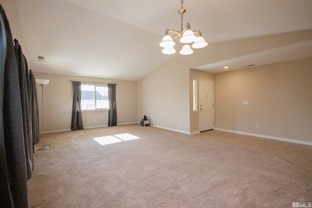 spare room featuring light carpet, vaulted ceiling, and an inviting chandelier