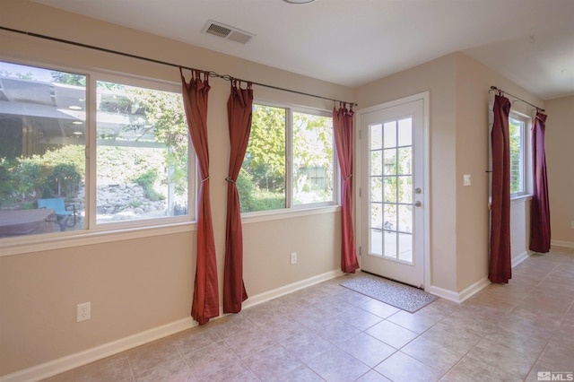 doorway to outside featuring light tile patterned floors and a healthy amount of sunlight