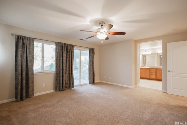 spare room featuring ceiling fan and light carpet