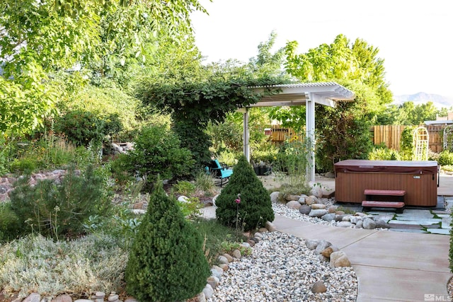 view of yard featuring a hot tub, a pergola, and a patio area