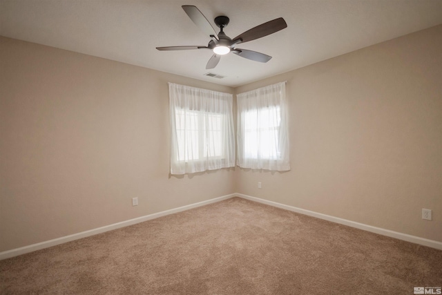 carpeted spare room featuring ceiling fan