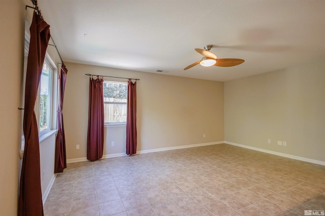 tiled empty room featuring ceiling fan