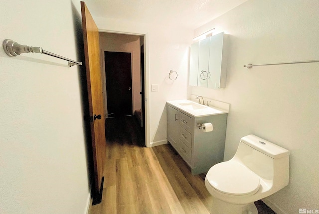 bathroom featuring hardwood / wood-style flooring, vanity, and toilet