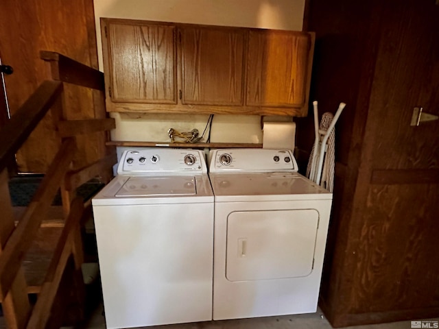 laundry room with washing machine and clothes dryer and cabinets