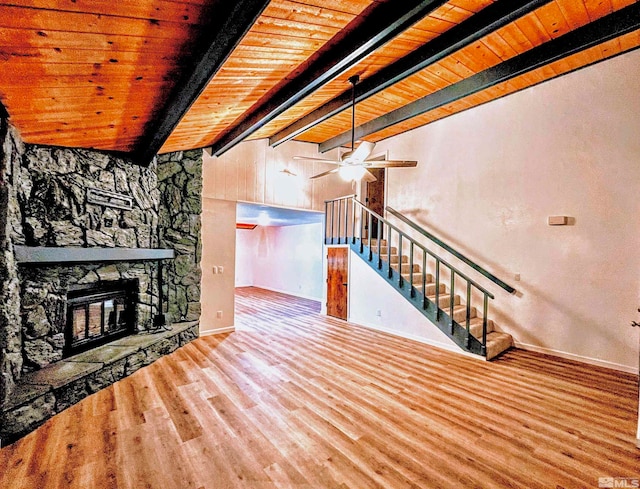 unfurnished living room with wooden ceiling, hardwood / wood-style flooring, ceiling fan, a fireplace, and beam ceiling