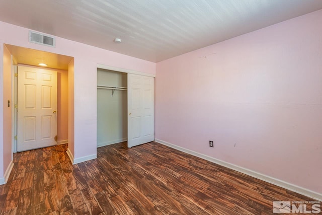 unfurnished bedroom with hardwood / wood-style flooring and a closet