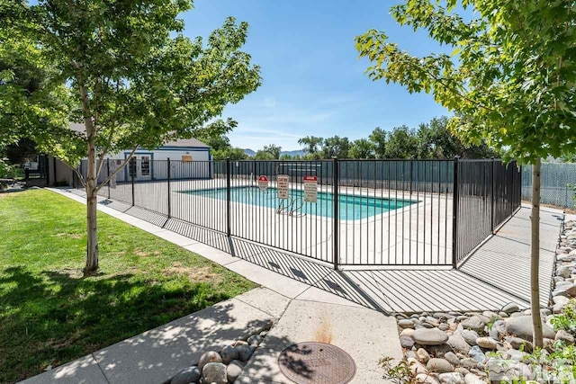 view of pool with a patio area and a yard