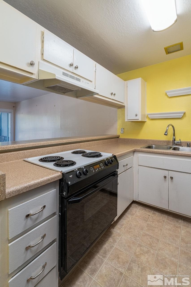 kitchen featuring sink, white electric stove, white cabinetry, and light tile patterned floors