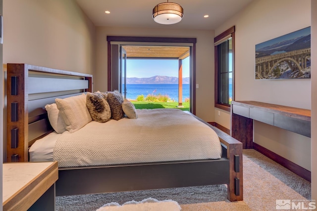 carpeted bedroom with a water view