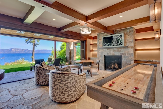 rec room featuring a fireplace, beam ceiling, a water and mountain view, and coffered ceiling