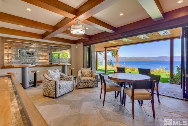 dining space with beamed ceiling, coffered ceiling, and a water and mountain view