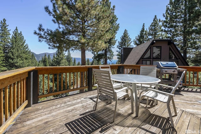 wooden deck with a mountain view and grilling area