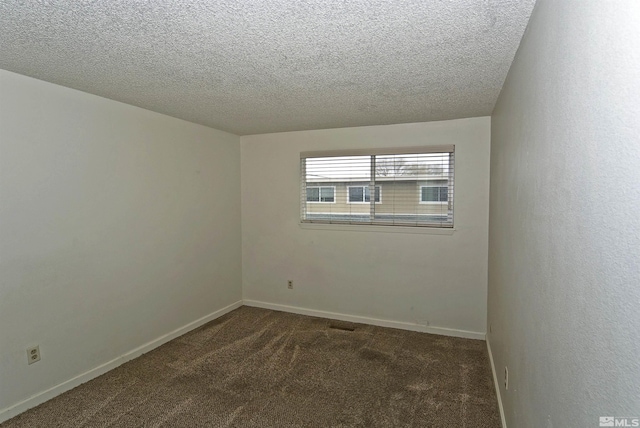 carpeted spare room featuring a textured ceiling and baseboards