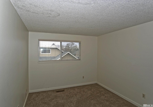 unfurnished room with carpet floors, visible vents, baseboards, and a textured ceiling