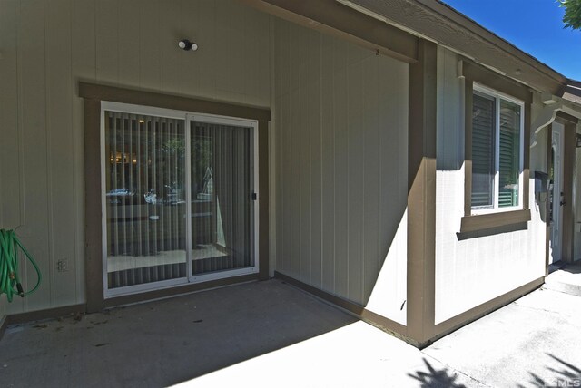 view of exterior entry featuring a patio area