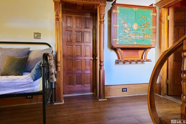 bedroom featuring hardwood / wood-style floors and wood walls