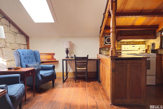 interior space featuring lofted ceiling with skylight and dark hardwood / wood-style flooring