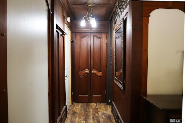 corridor with an inviting chandelier and dark hardwood / wood-style floors