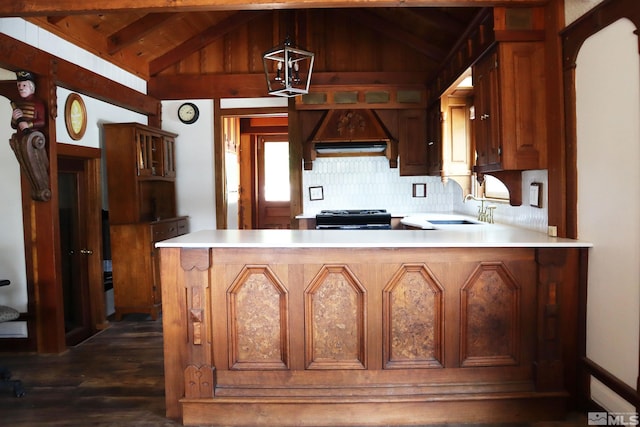 kitchen featuring sink, kitchen peninsula, black range, and premium range hood