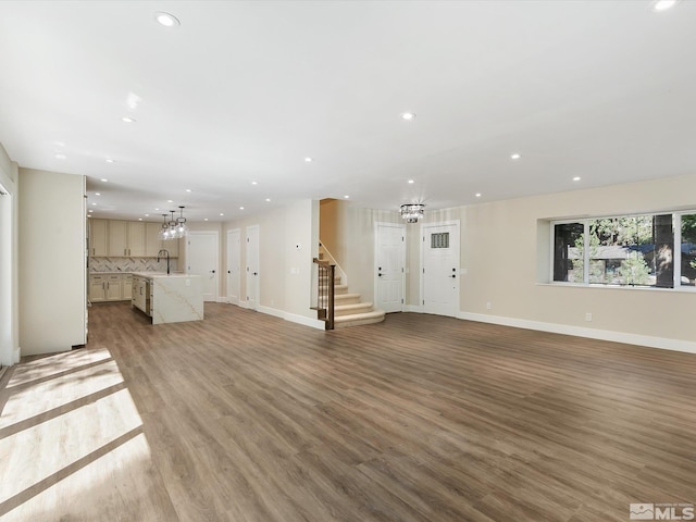 unfurnished living room with sink and light hardwood / wood-style floors