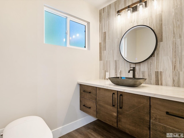 bathroom featuring wood-type flooring, toilet, and vanity