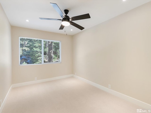 carpeted spare room with ceiling fan