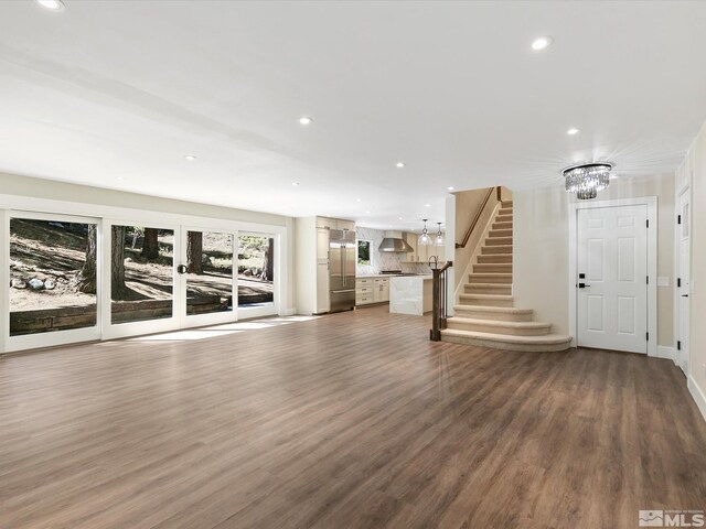 unfurnished living room with a notable chandelier and wood-type flooring