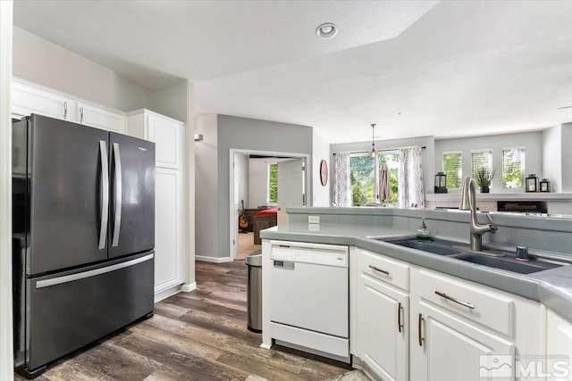 kitchen featuring stainless steel refrigerator, white cabinetry, sink, dark hardwood / wood-style flooring, and white dishwasher