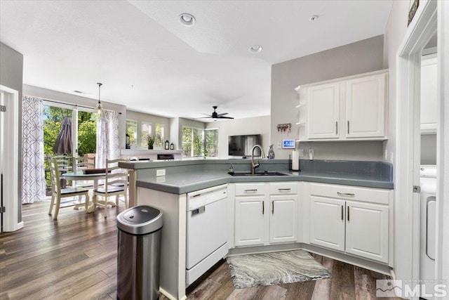 kitchen featuring a sink, dark wood-style floors, a peninsula, white cabinets, and dishwasher