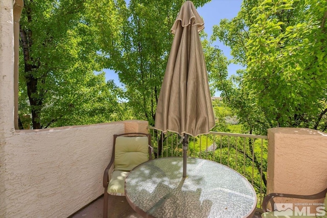 view of patio with outdoor dining area and a balcony