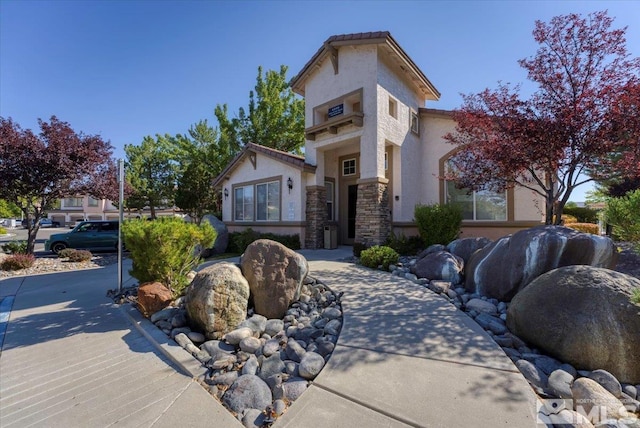 mediterranean / spanish home with stone siding and stucco siding