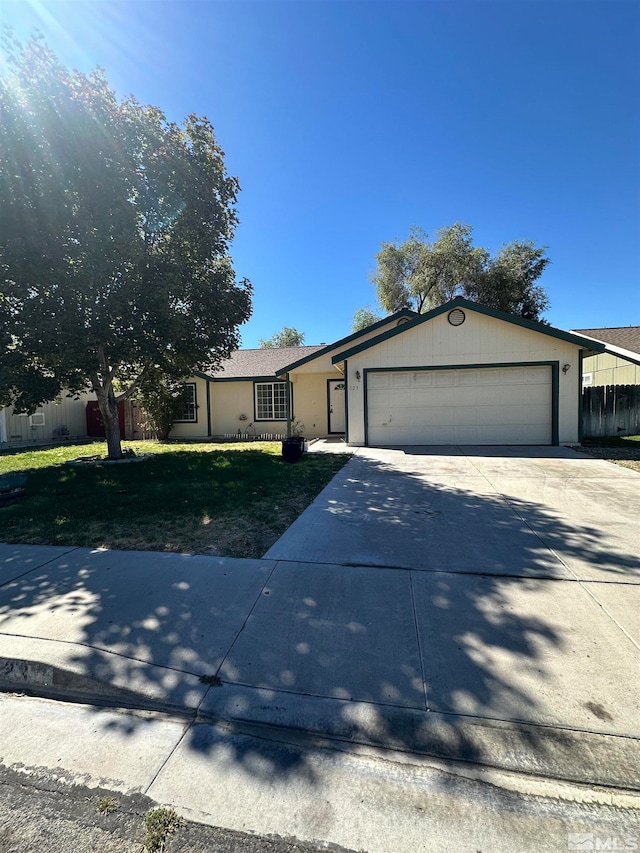 ranch-style house featuring a garage and a front lawn