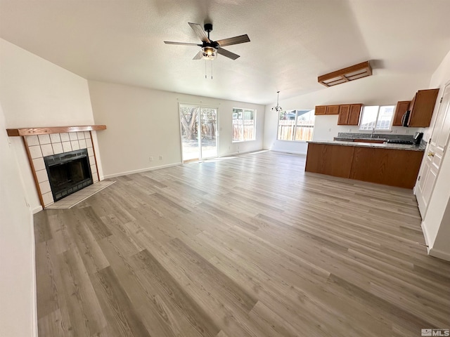 unfurnished living room featuring a wealth of natural light, vaulted ceiling, and light hardwood / wood-style flooring