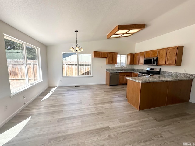 kitchen featuring a notable chandelier, light hardwood / wood-style flooring, stainless steel appliances, kitchen peninsula, and lofted ceiling