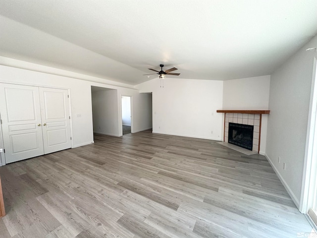 unfurnished living room featuring light hardwood / wood-style floors, ceiling fan, and a fireplace