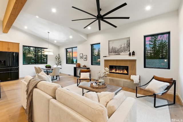 living room with baseboards, a tile fireplace, lofted ceiling with beams, light wood-style flooring, and recessed lighting