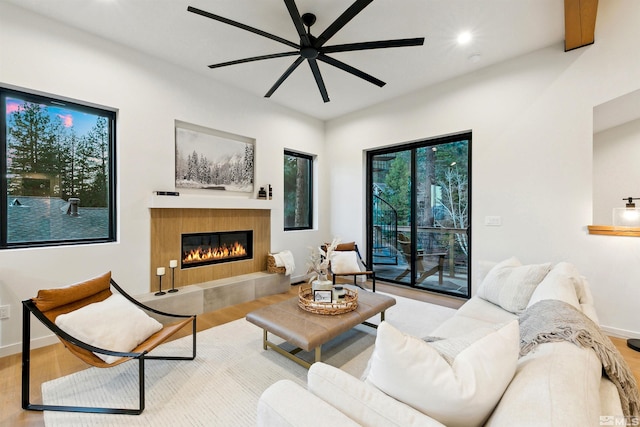 living area featuring baseboards, a tiled fireplace, ceiling fan, wood finished floors, and recessed lighting