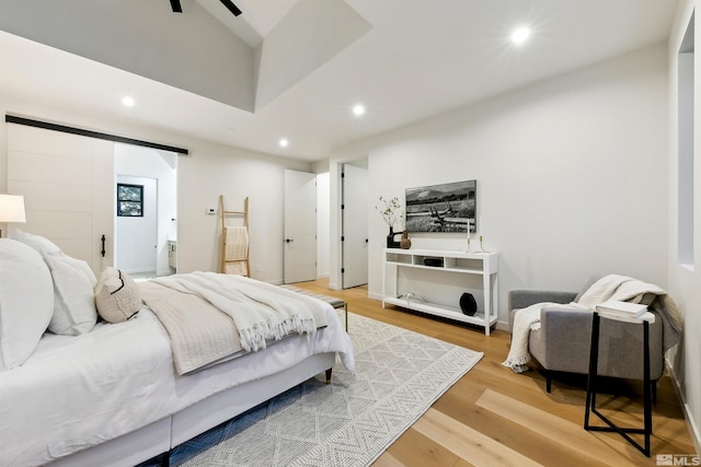 bedroom featuring ensuite bath, wood finished floors, and recessed lighting