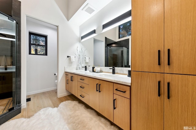 bathroom with double vanity, visible vents, toilet, a sink, and a shower stall