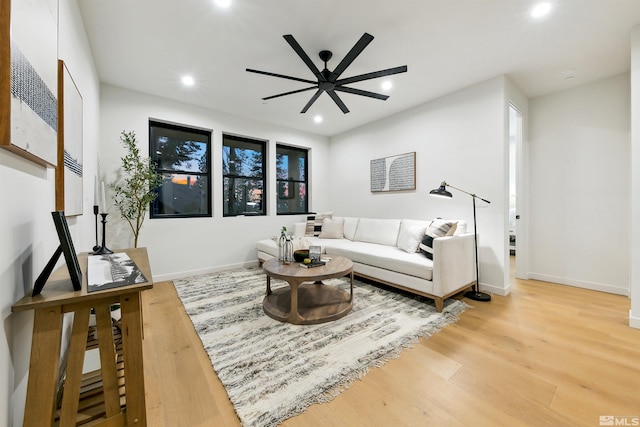 living area featuring light wood-style flooring, baseboards, ceiling fan, and recessed lighting