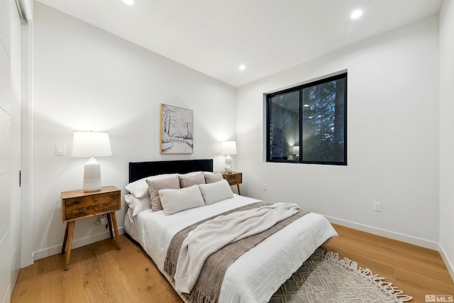 bedroom with recessed lighting, baseboards, and wood finished floors