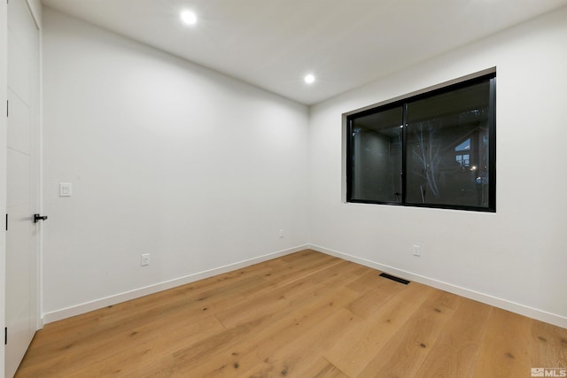 spare room with recessed lighting, visible vents, baseboards, and wood finished floors