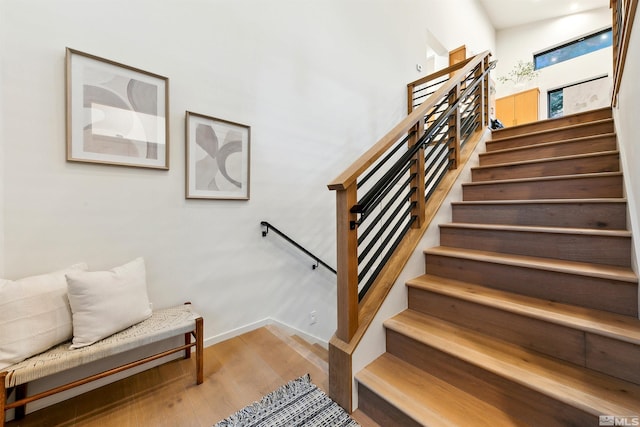 stairway with wood finished floors and baseboards