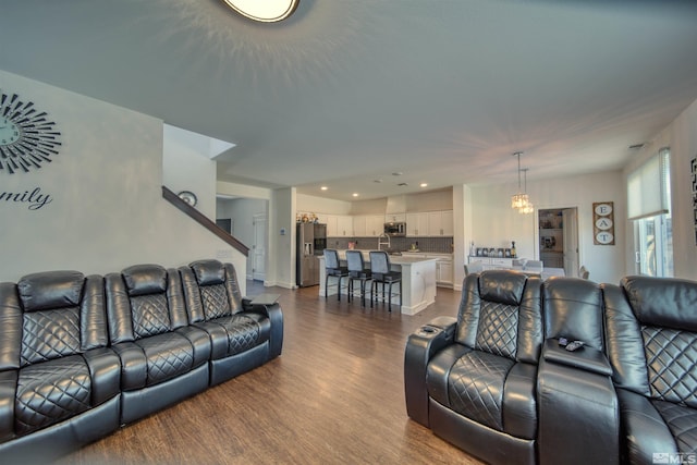 living room with hardwood / wood-style flooring and a notable chandelier