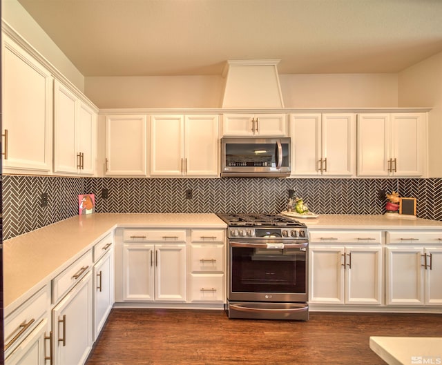 kitchen featuring white cabinets, backsplash, appliances with stainless steel finishes, and dark hardwood / wood-style floors