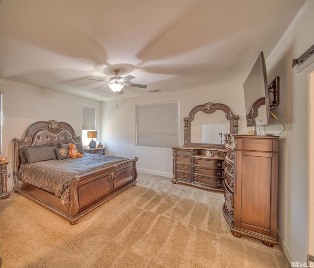 bedroom featuring carpet, a barn door, and ceiling fan