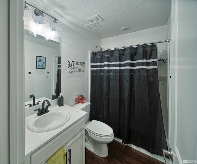 bathroom featuring hardwood / wood-style floors, toilet, a textured ceiling, and vanity